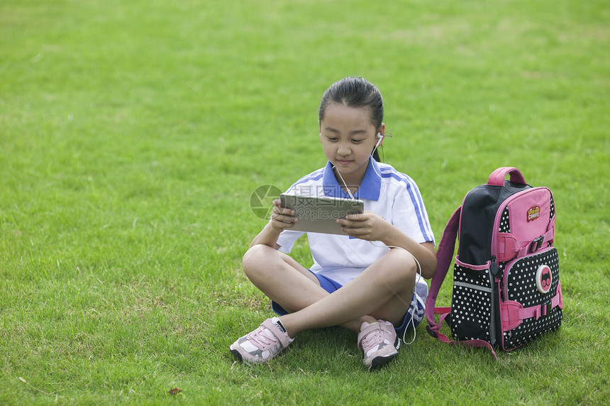 女同学在学校草坪上用ipad学习图片