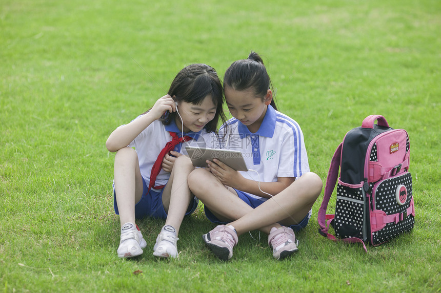 女同学在学校里草坪上用ipad 学习图片