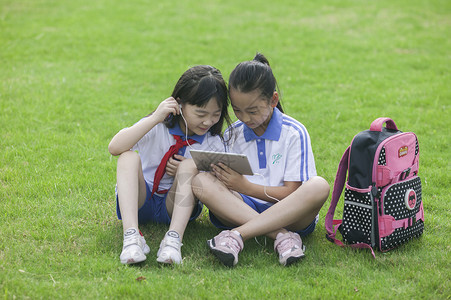 女同学在学校里草坪上用ipad 学习图片