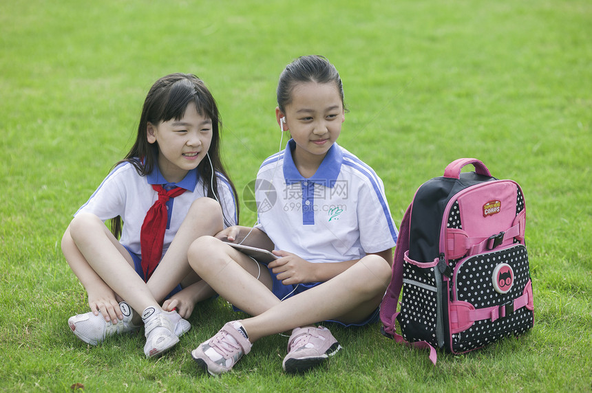 女同学在学校里草坪上用ipad 学习图片