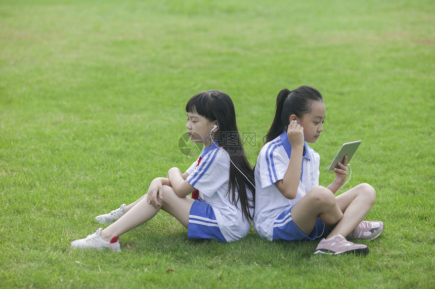 女同学在学校里草坪上用ipad 学习图片