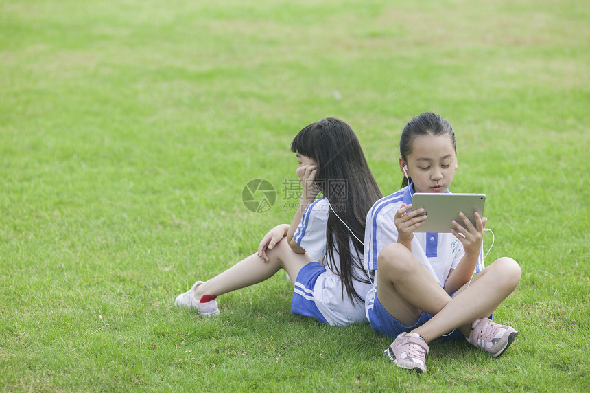 女同学在学校里草坪上用ipad 学习图片