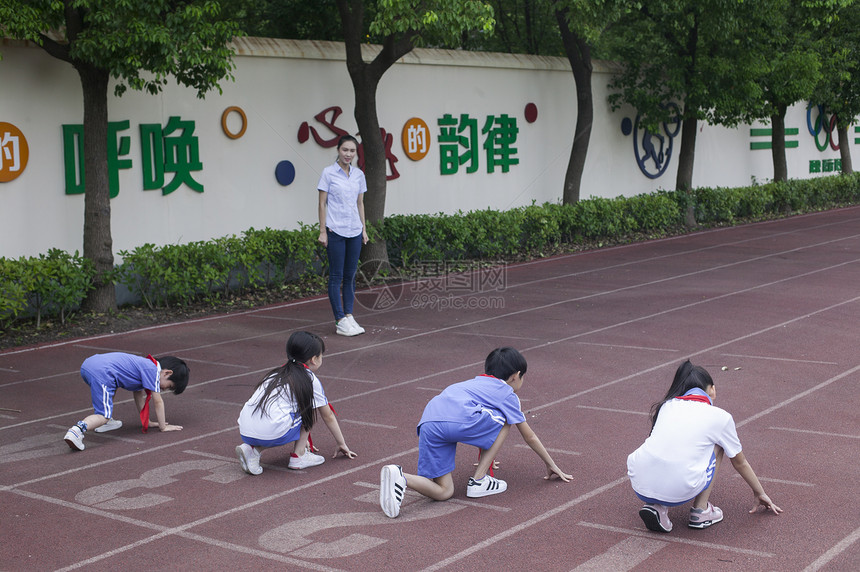 男女同学在操场跑道上比赛跑步图片