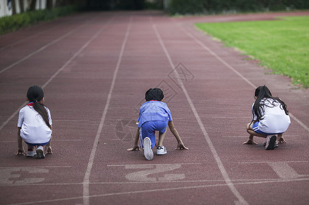 起点终点男女同学在操场跑道上比赛跑步背景