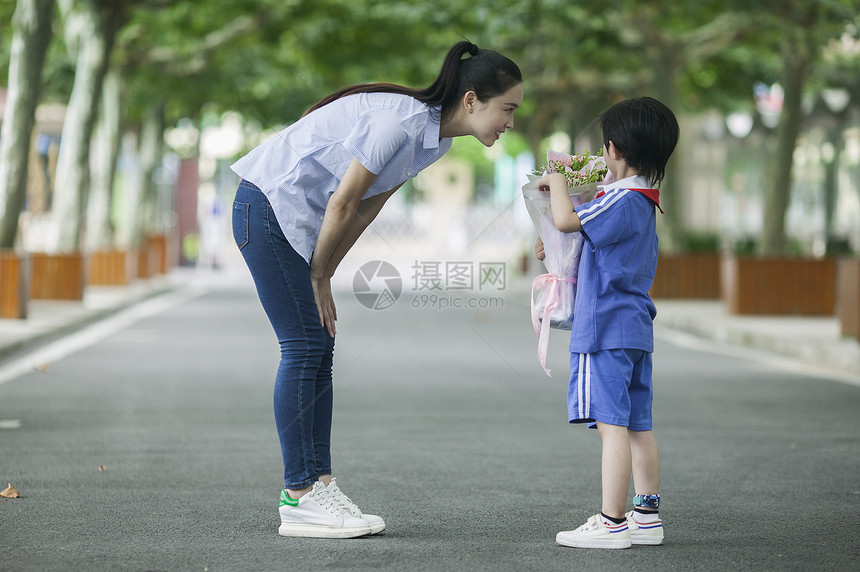 教师节男同学在校园里给老师献花图片