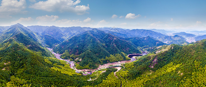 山林度假航拍大山中的村庄与水库背景