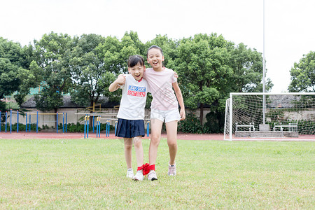 二人三足小学生在草坪操场上玩游戏背景