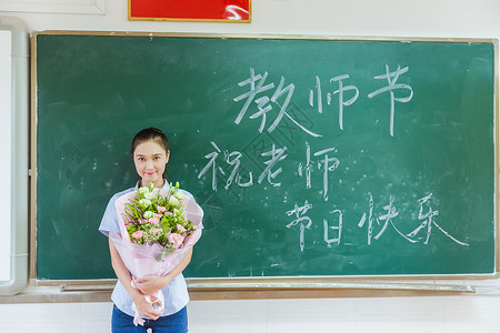 感恩师恩难忘教师节老师拿着花在黑板前背景