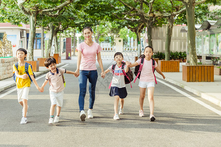 教师节老师牵着学生们上学背景图片