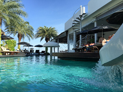 太阳伞躺椅海岛上的别墅泳池背景