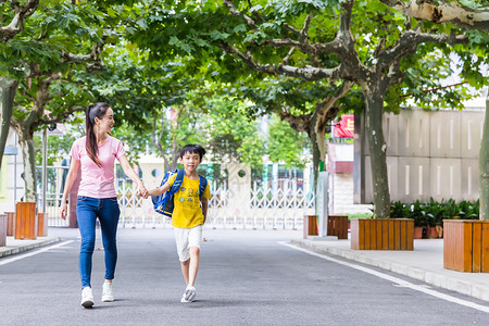 牵着妈妈的孩子校园亲子妈妈牵着儿子上学背景