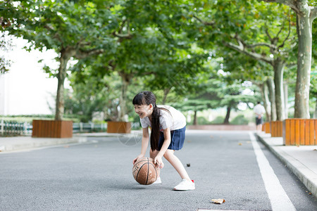 卡通女生打篮球校园林荫道上打篮球的小学生女生背景