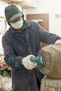 木匠师傅用电动磨具磨砂木料背景图片