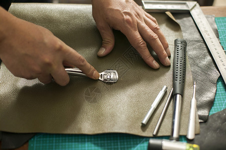 钻子皮匠师傅在制作皮革成品背景