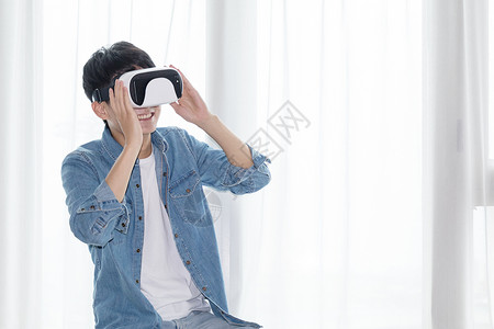 场景体验年轻男子在客厅体验虚拟现实VR眼镜背景