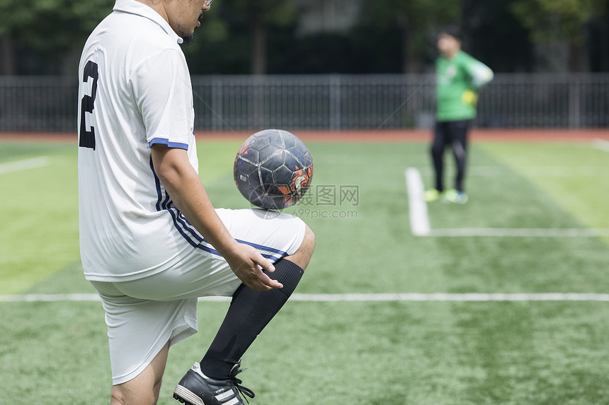 足球运动员在草坪上训练踢球