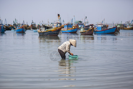 渔民捕捞海边渔民在专注的劳作背景