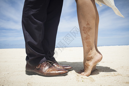 旅行蜜月中情侣在沙滩踮起脚尖亲吻图片