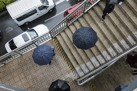 雨天里回忆城市里雨天人们打着伞背景