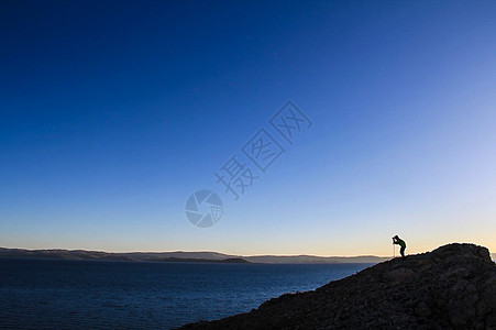 黄昏中的山脉上的摄影家背景图片