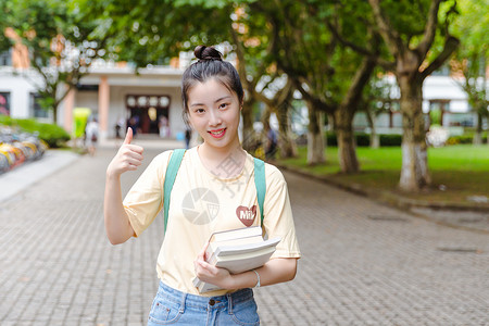 大学校园内女生抱着书本高清图片