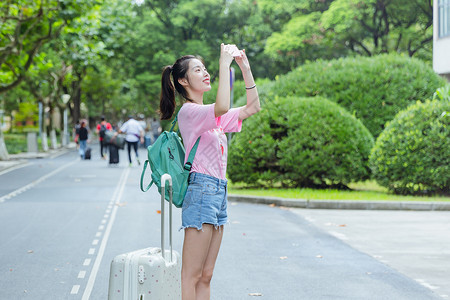 粉色旅行箱大学校园女生拍照背景