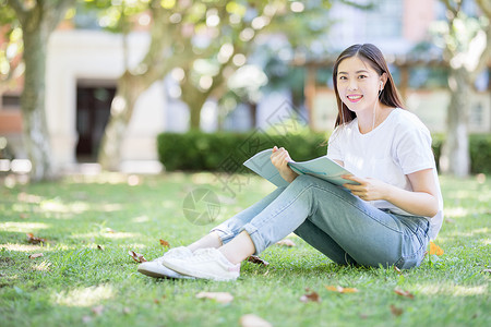 长发美女买买买坐在校园草坪上看书的女学生背景