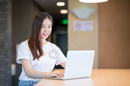 商务办公女性看电脑使用的电脑的年轻女性背景