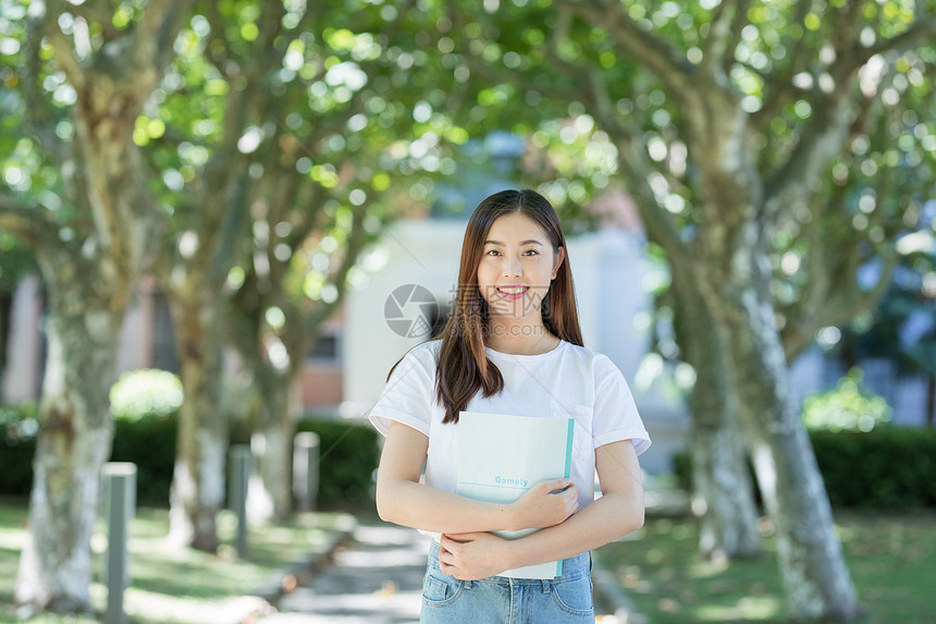 走在校园林荫道下的甜美女生图片