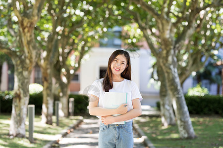 走在校园林荫道下的甜美女生高清图片