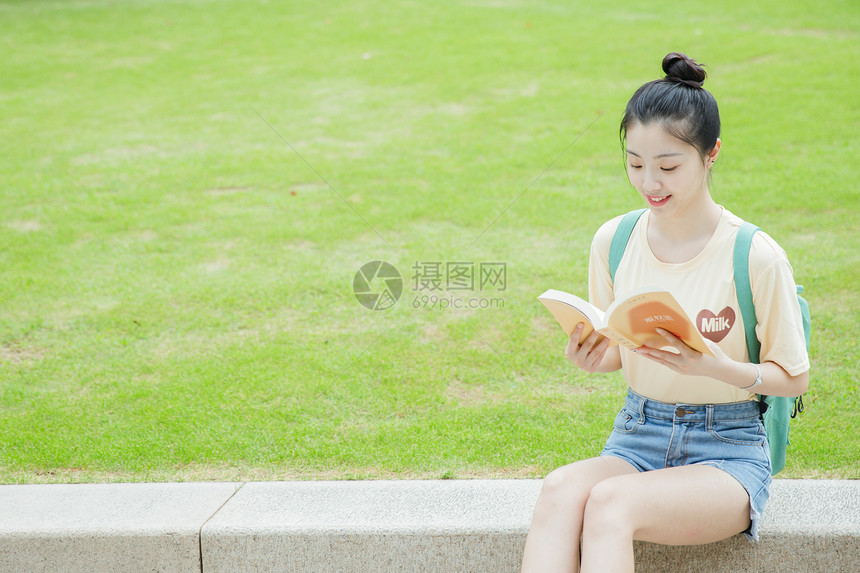 校园草地前女生在看书图片