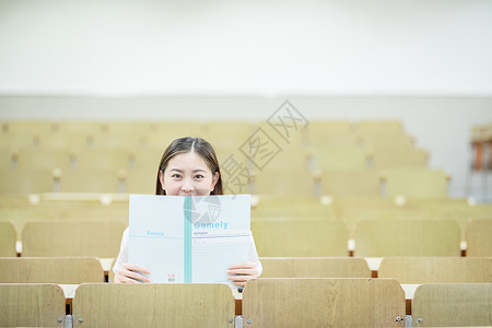 教室里用书挡着脸的可爱女生高清图片