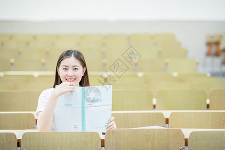 教室里用书挡着脸的可爱女生高清图片