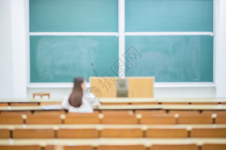 空旷的教室里正在学习的女生背影背景图片