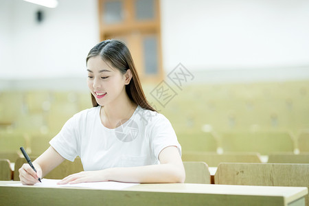 教室里自习学习写字的女大学生高清图片