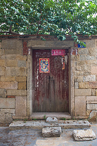 古宅石头墙和红木门背景图片
