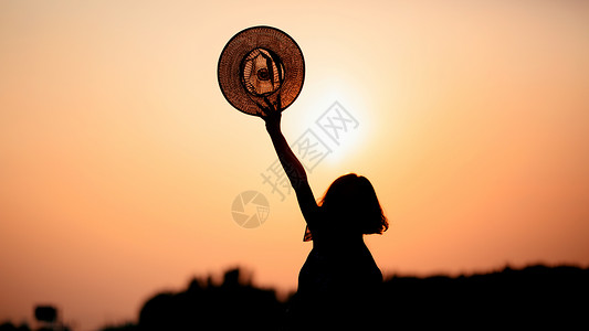 太阳帽夕阳下的女性背影背景