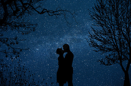 夜晚树木星空下拥吻的情侣背景