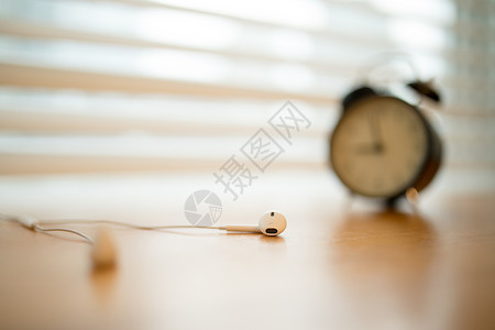 简洁大气的闹钟特写图片放在桌子上的耳机文艺特写背景