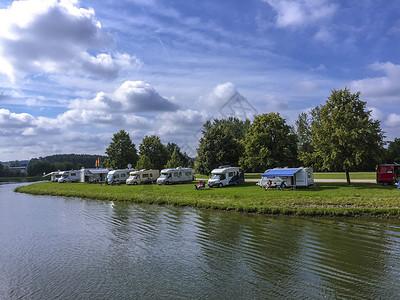 房车基地欧洲河岸上的休闲度假房车背景