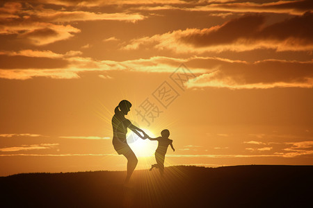 高兴孩子夕阳下玩耍的母子设计图片