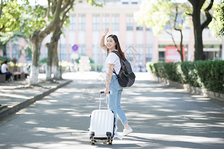 拉着行李箱的女生背影背景图片