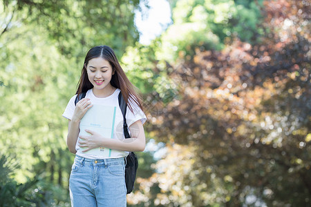 校园里背着书包抱着书的同学图片