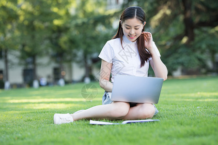 绿色草坪上休闲学习的女生图片