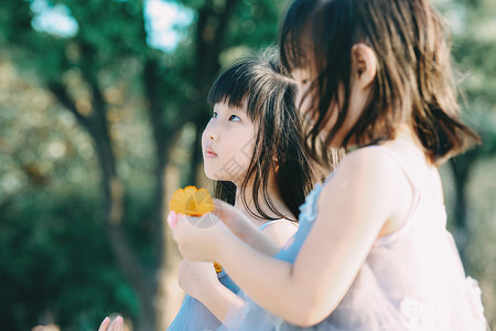 芭比和妹妹抬头仰望的儿童双胞胎背景