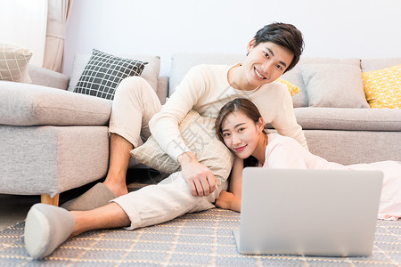 情侣看电脑坐在沙发上看电脑的情侣背景