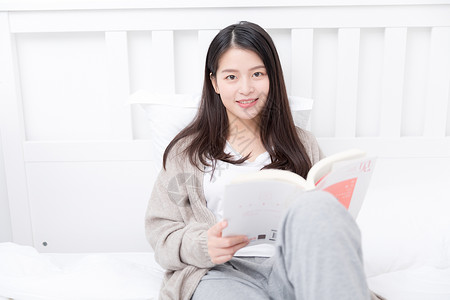 坐在床上看书的女生高清图片