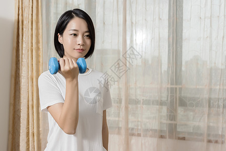 女子在家用哑铃锻炼高清图片