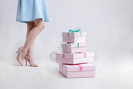 连衣裙促销站在礼物盒旁边的年轻美女背景