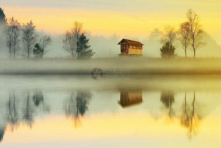 清晨乡村充满雾气的湖边倒影图片